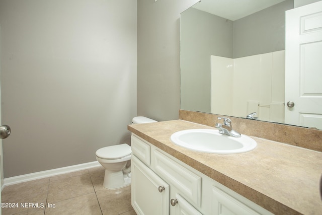 bathroom featuring tile patterned flooring, vanity, toilet, and walk in shower