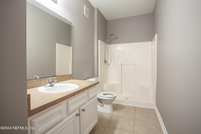 bathroom featuring tile patterned floors, vanity, toilet, and walk in shower