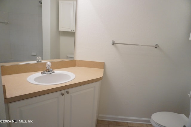 bathroom featuring toilet, tile patterned flooring, baseboards, and vanity