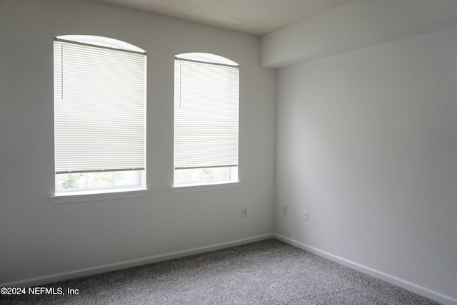 unfurnished room with carpet floors and baseboards