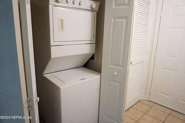 laundry room with laundry area, stacked washer / dryer, and light tile patterned flooring