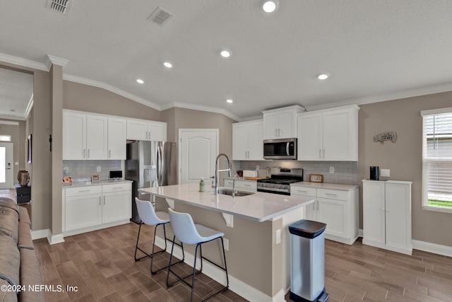 kitchen featuring stainless steel appliances, white cabinetry, a kitchen island with sink, and sink