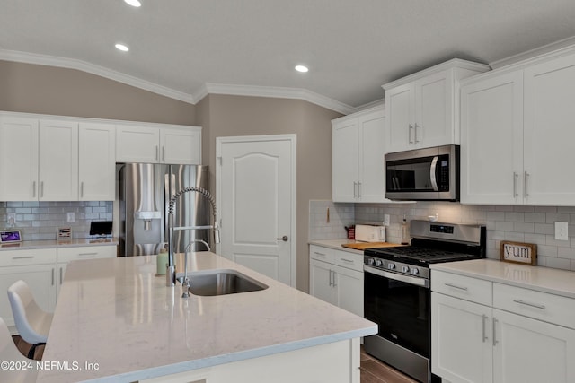 kitchen featuring white cabinets, stainless steel appliances, vaulted ceiling, and crown molding