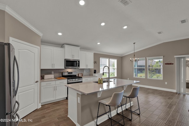 kitchen with white cabinetry, sink, decorative light fixtures, a center island with sink, and appliances with stainless steel finishes