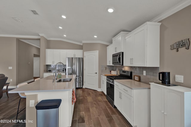 kitchen with white cabinetry, a center island with sink, lofted ceiling, and appliances with stainless steel finishes