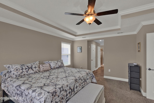 bedroom featuring a raised ceiling, ceiling fan, carpet flooring, and ornamental molding