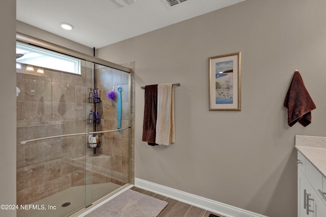 bathroom with vanity and a shower with door