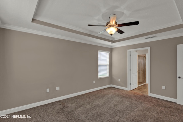 unfurnished room featuring a tray ceiling, ceiling fan, crown molding, and light colored carpet