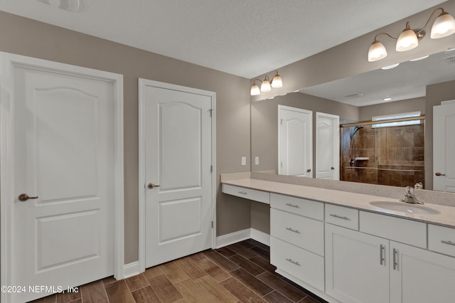 bathroom with vanity, a textured ceiling, and walk in shower