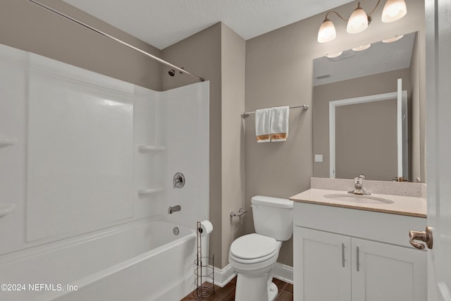 full bathroom with tub / shower combination, vanity, a textured ceiling, wood-type flooring, and toilet