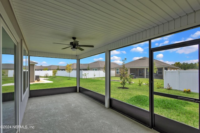 unfurnished sunroom with ceiling fan