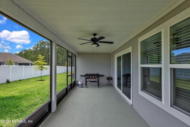 unfurnished sunroom with ceiling fan