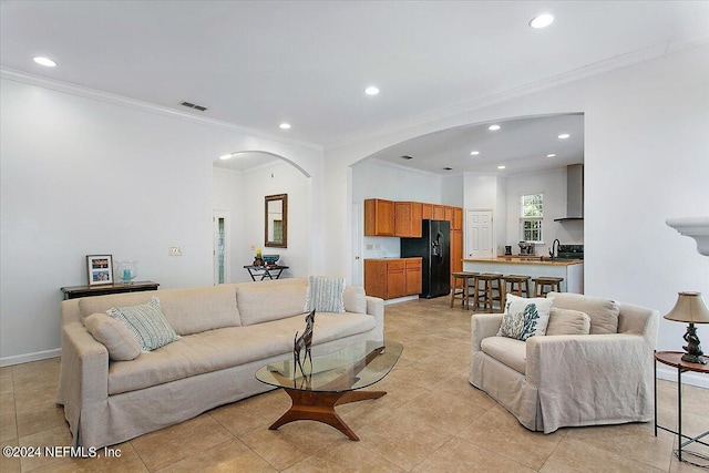 tiled living room featuring ornamental molding and sink