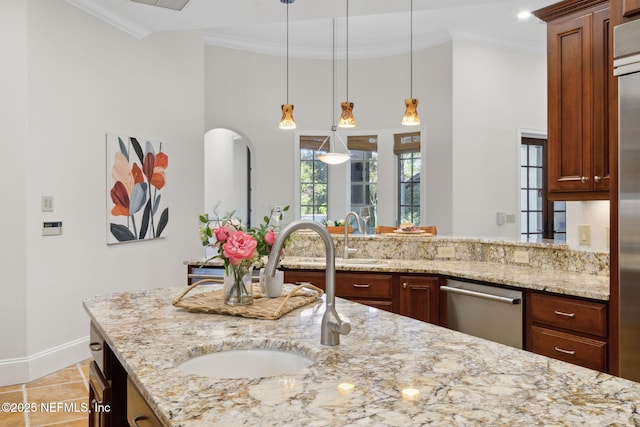 kitchen with dishwasher, light stone counters, ornamental molding, hanging light fixtures, and a sink