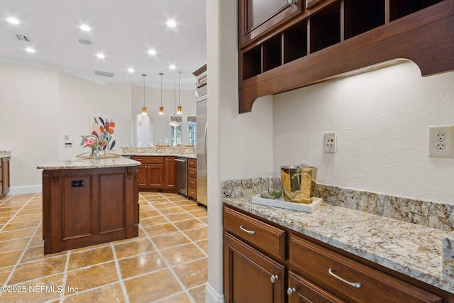 kitchen with a center island, recessed lighting, visible vents, hanging light fixtures, and light stone countertops