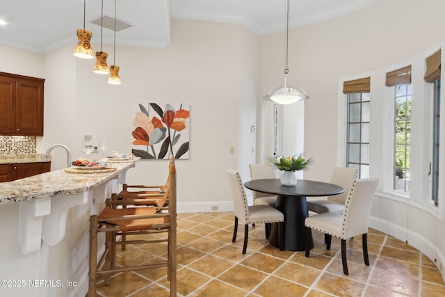 dining space with baseboards, visible vents, ornamental molding, and light tile patterned flooring