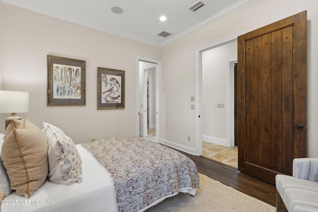 bedroom with baseboards, dark wood-type flooring, visible vents, and crown molding