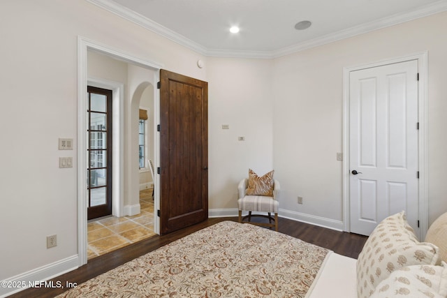 living area with arched walkways, ornamental molding, dark wood-style flooring, and baseboards