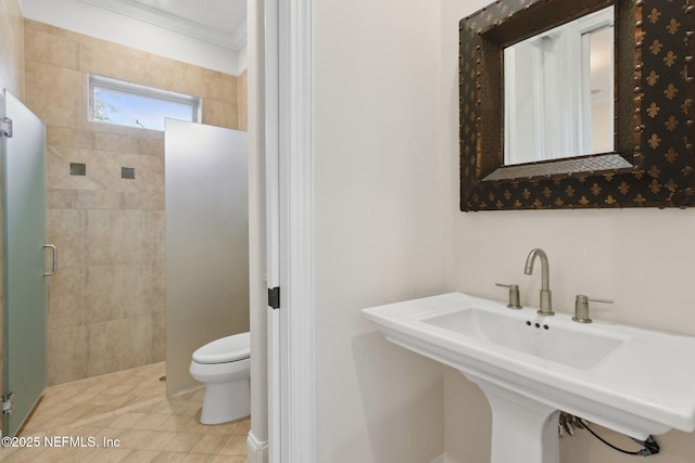 bathroom with ornamental molding, a sink, a shower stall, and toilet