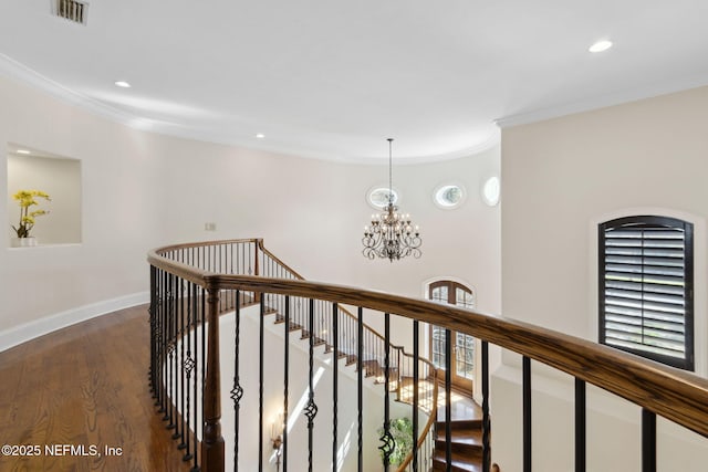 hallway with visible vents, ornamental molding, dark wood-type flooring, an upstairs landing, and baseboards