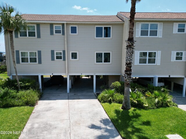 view of front of house with a carport and a front lawn