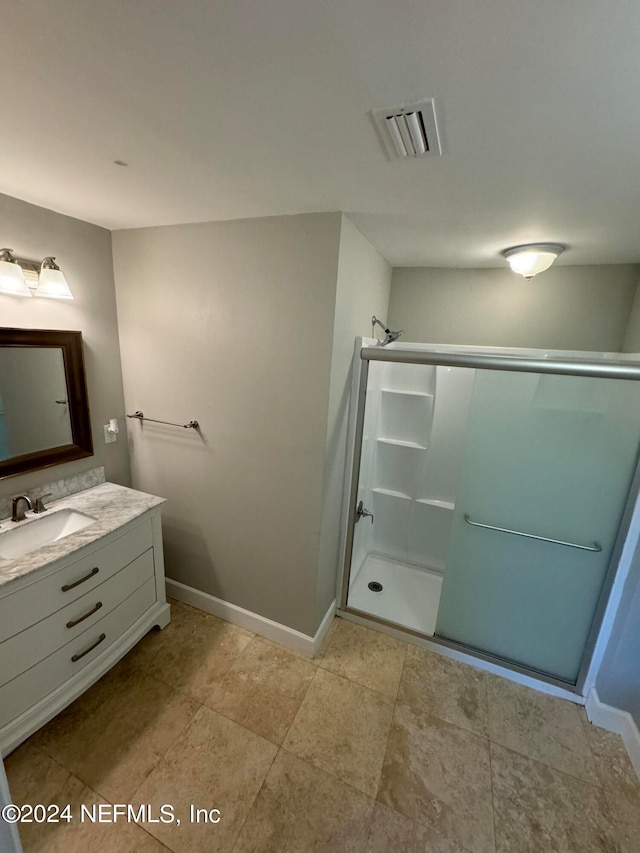 bathroom with an enclosed shower, tile flooring, and vanity