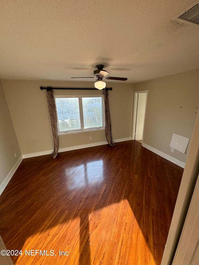 empty room with a textured ceiling, ceiling fan, and hardwood / wood-style floors