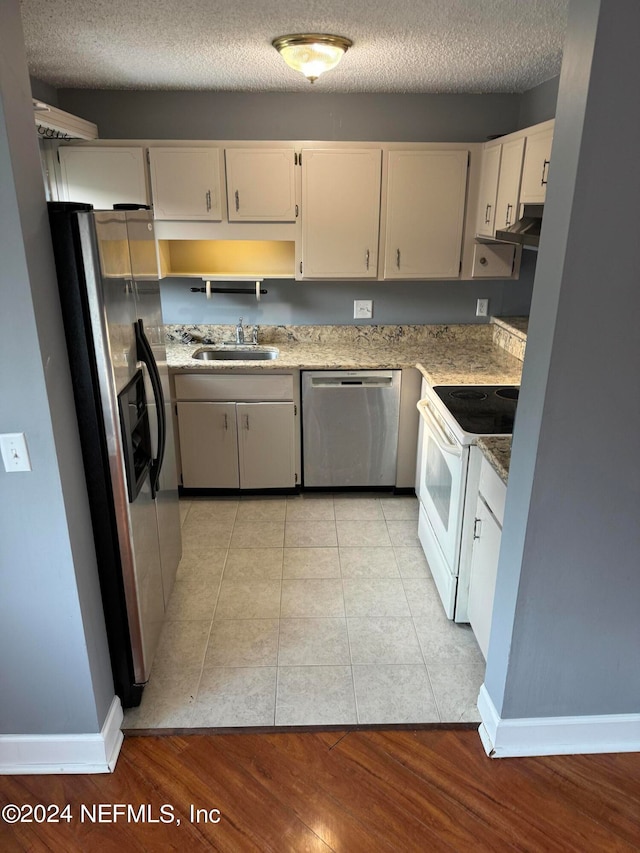 kitchen with white cabinetry, a textured ceiling, stainless steel appliances, light hardwood / wood-style flooring, and sink