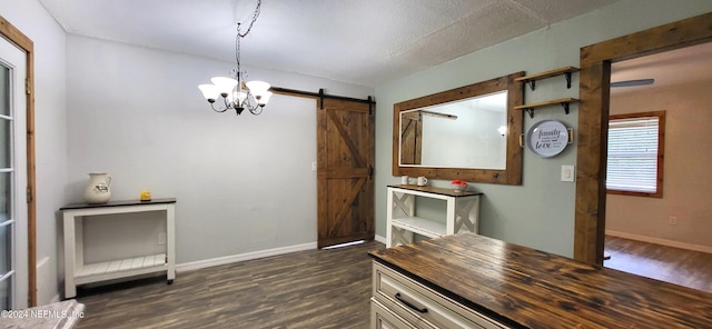 interior space featuring dark hardwood / wood-style floors, a barn door, a textured ceiling, and a chandelier