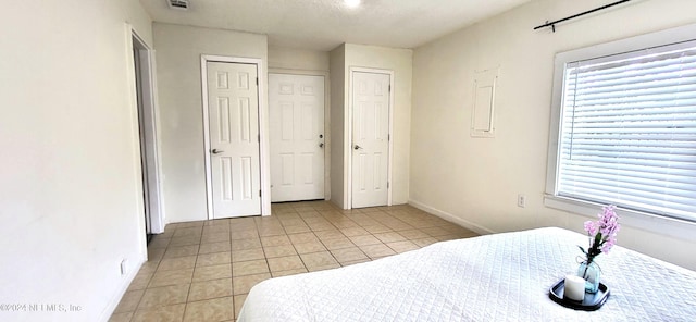 tiled bedroom featuring two closets