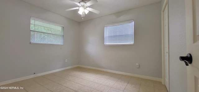 tiled spare room with ceiling fan