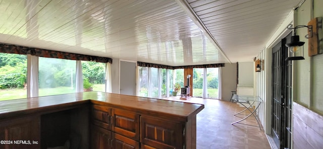 sunroom / solarium featuring bar and plenty of natural light