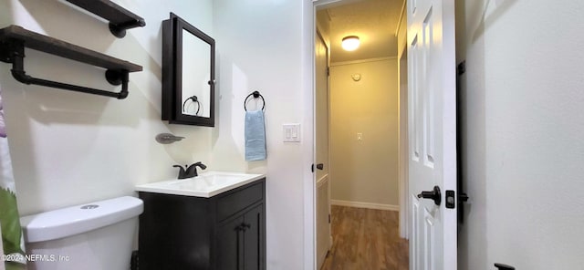 bathroom with vanity, hardwood / wood-style flooring, and toilet