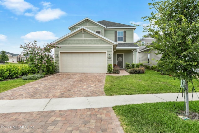 craftsman house featuring a garage and a front lawn