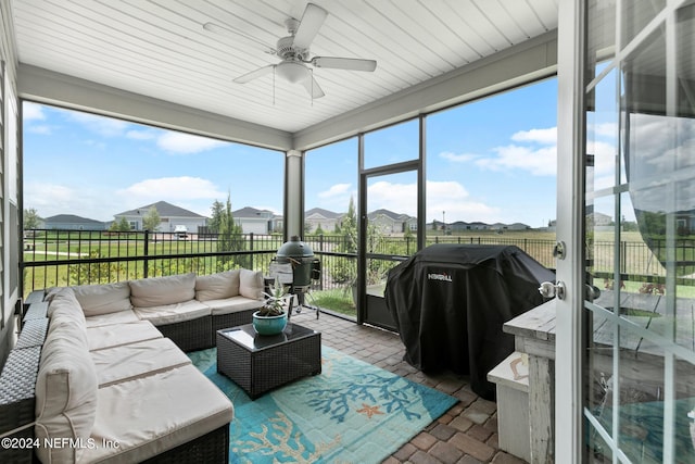 sunroom / solarium featuring ceiling fan