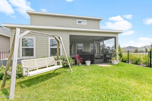 rear view of property with a lawn and a sunroom