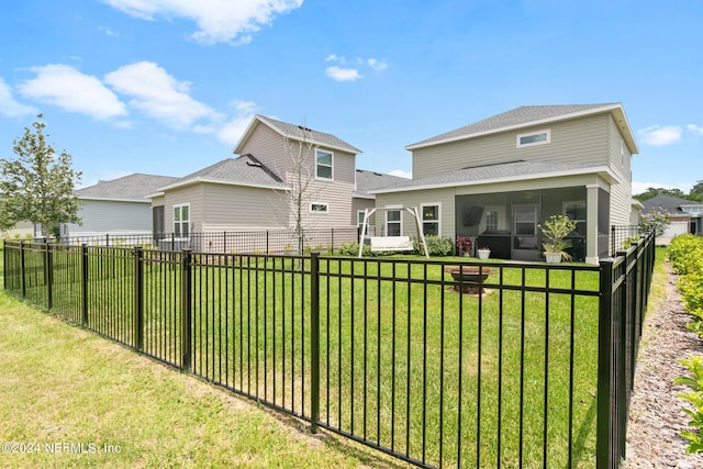 back of property with a sunroom and a yard