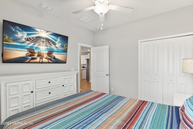 bedroom featuring a closet, stainless steel refrigerator, and ceiling fan