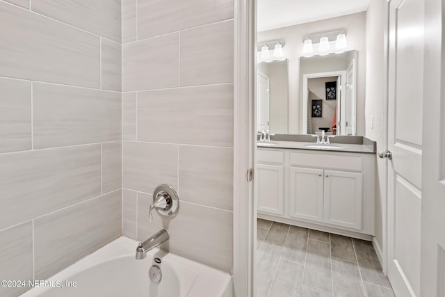 bathroom featuring hardwood / wood-style floors, vanity, and washtub / shower combination