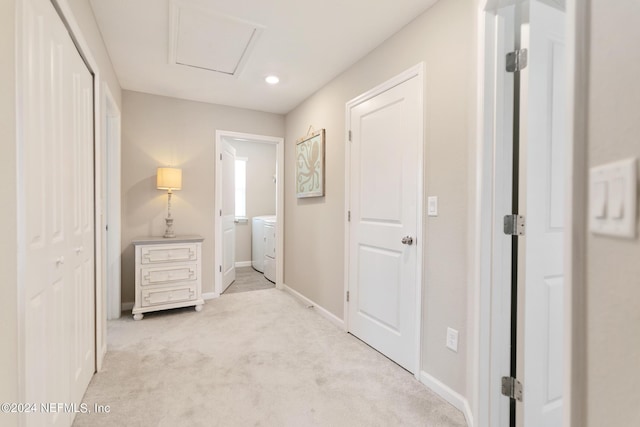 corridor with light carpet and washer / dryer