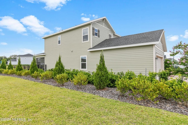 view of side of property with a yard and a garage