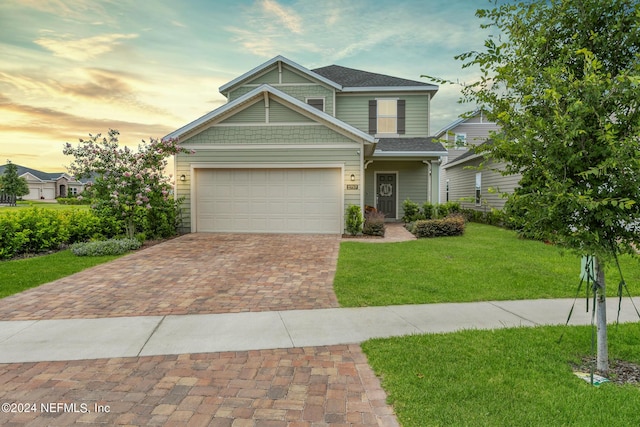 craftsman-style home featuring a garage and a yard