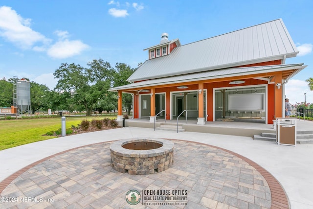 rear view of property featuring an outdoor fire pit