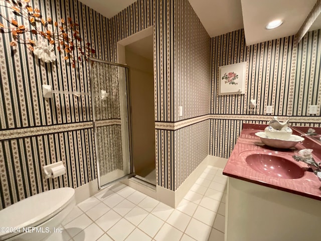 bathroom with double vanity, toilet, and an enclosed shower