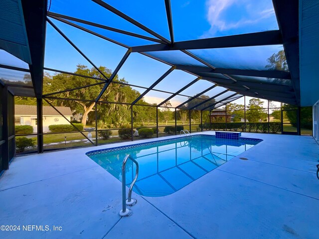 view of swimming pool with glass enclosure and a patio area