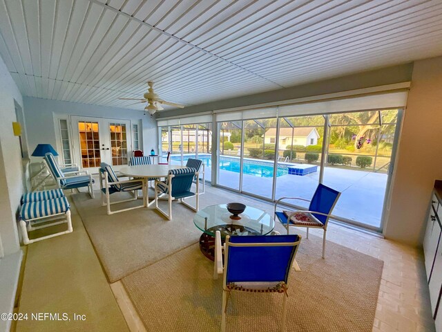 sunroom / solarium featuring a healthy amount of sunlight, french doors, and ceiling fan