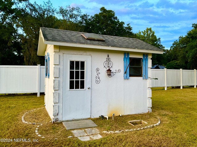 view of outbuilding featuring a lawn