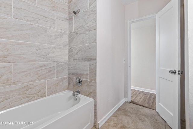 bathroom featuring wood-type flooring and tiled shower / bath combo