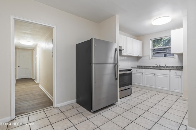 kitchen featuring sink, decorative backsplash, light wood-type flooring, appliances with stainless steel finishes, and white cabinetry