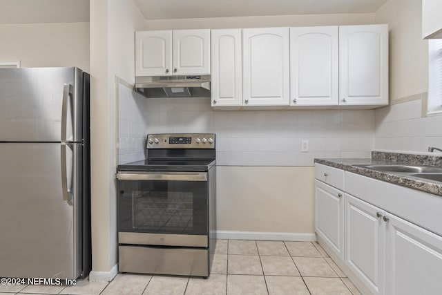 kitchen with decorative backsplash, appliances with stainless steel finishes, white cabinetry, and light tile patterned flooring